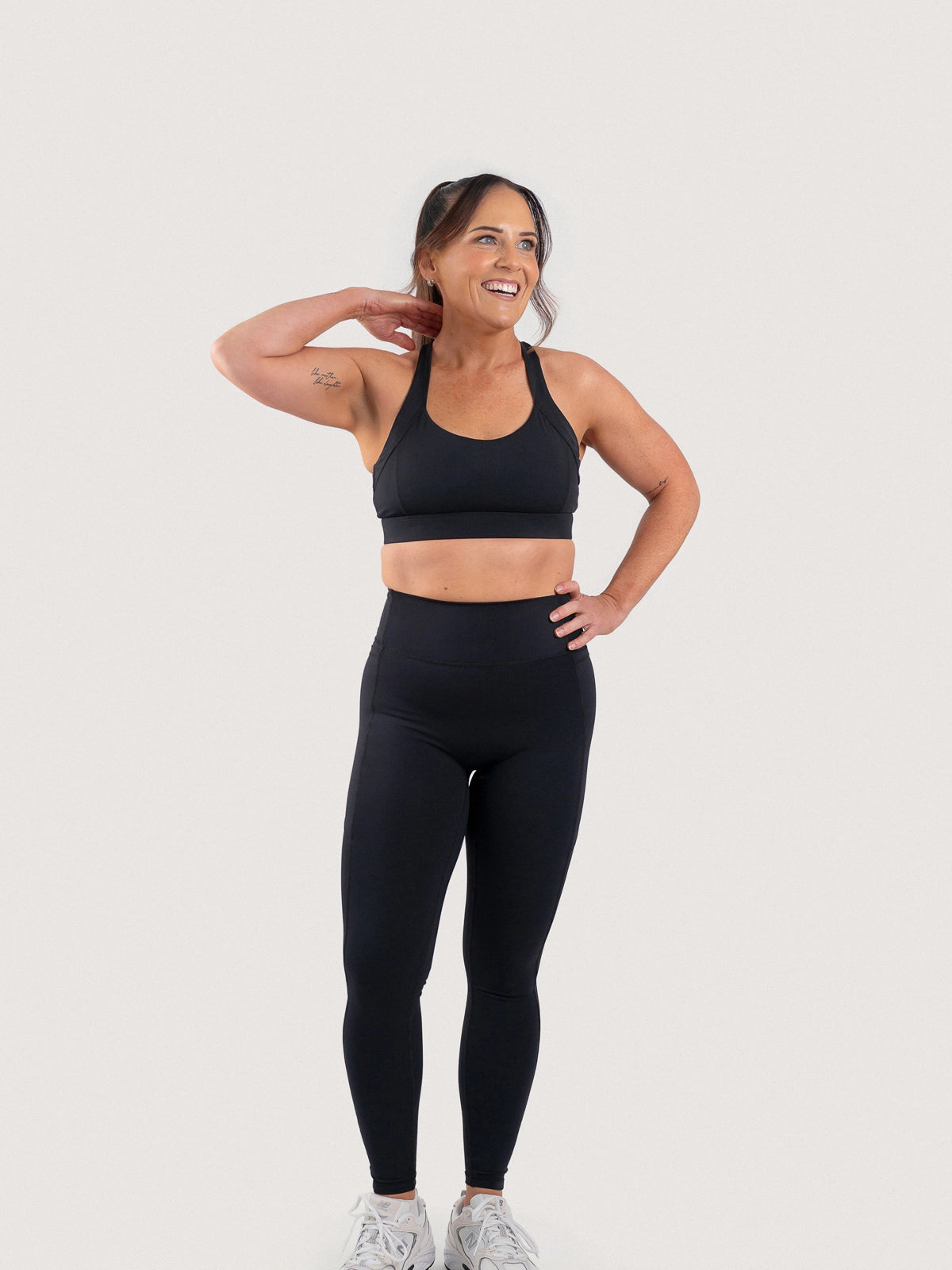 Full-length front view of the Aella Storm Hybrid Leggings
and Sports Bra in Black.