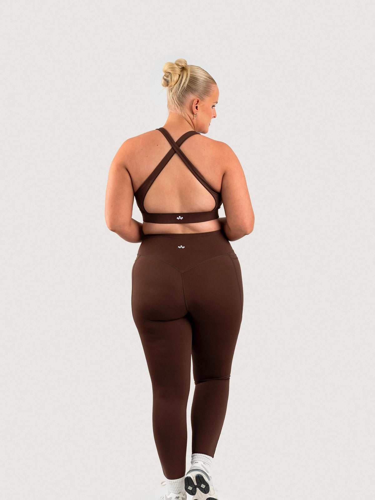 Full-length back view of the Aella Storm Hybrid Leggings and Sports Bra in Espresso.