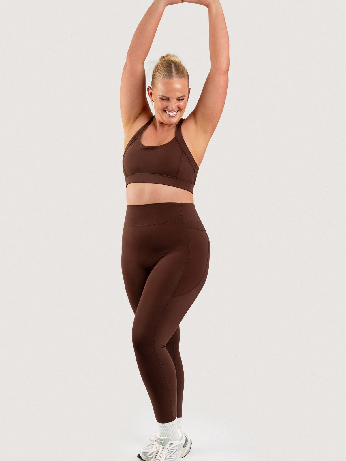 Full-length front view of the Aella Storm Hybrid Leggings and Sports Bra in Espresso.