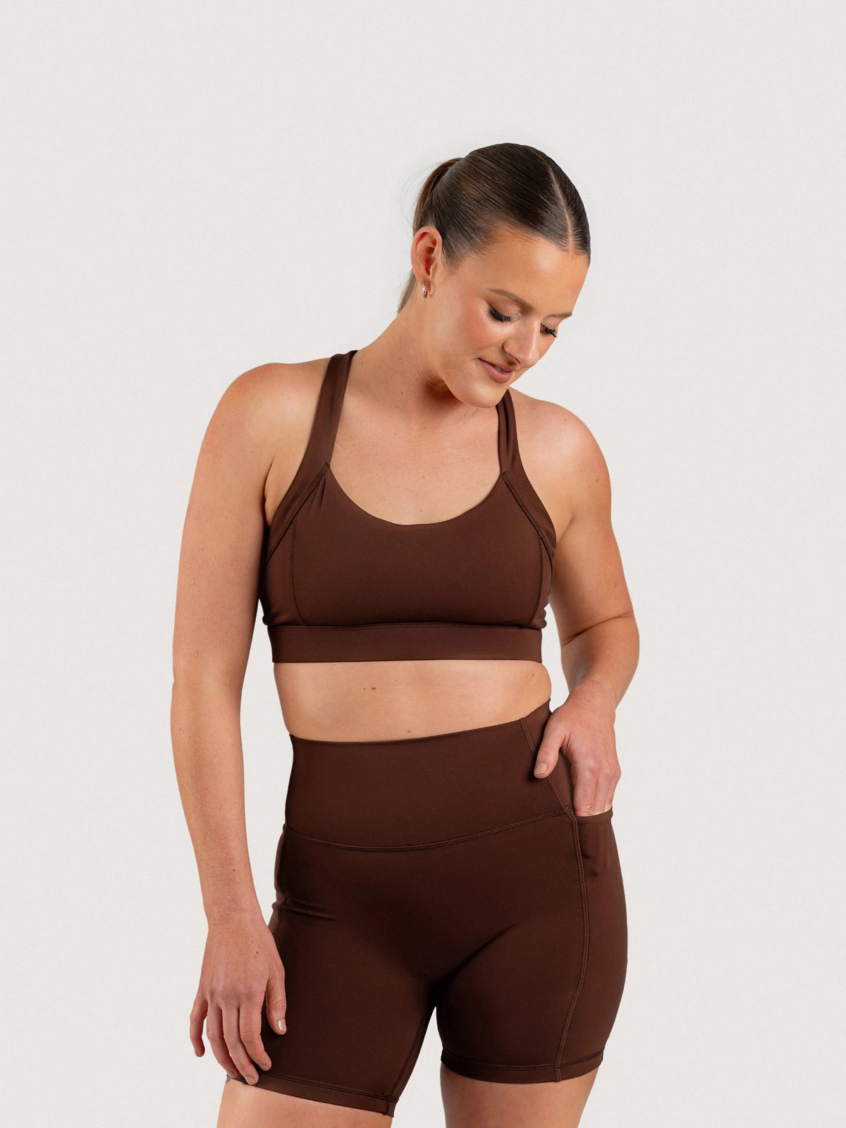 Front view of the Aella Storm Hybrid Shorts and Sports Bra
in Espresso.